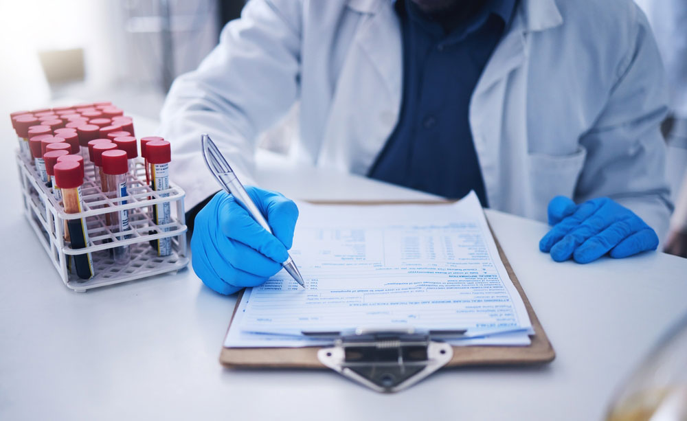 a medical doctor inspecting medical tubes with blood specimen